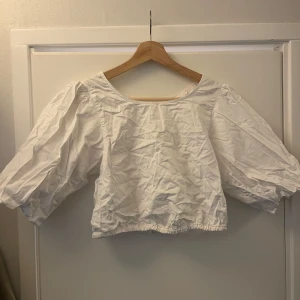 Vit topp med Puffärm - Jättesöt topp med puffärm. Behöver strykas innan användning. Går att använda åt båda hållen. Storlek 38.