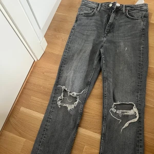 Grå ripped jeans från Zara, strl 38 - Snygga grå jeans från Zara i storlek 38 med slitna hål över knäna för en cool, avslappnad vibe. Pris kan diskuteras 