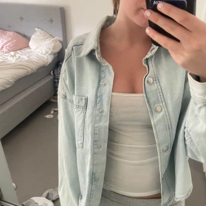 Ljusblå  jeansjacka - En jätte snygg jeans Jacka som knappt är använd , är storlek m men skulle säga att den passar xs-m. Den har en avslappnad, oversized passform. .