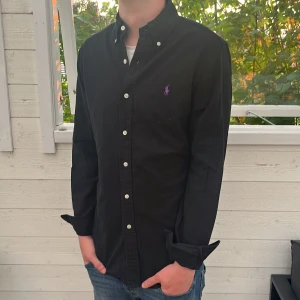 Svart Ralph lauren skjorta - Säljer jätte fin Ralph lauren skjorta, inga tecken på användning och jätte bra skick, nypris är 1699kr och den postas inom 48h