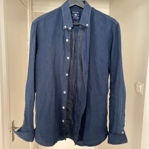 Robbie Moor - En rutigt snygg navy blå linne skjorta som är i nyskick och använts en gång. Nypris ligger på runt 1199kr men här kan den köpas för bara 499. Vid fler frågor är det bara att skriva. 