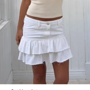 Vit volang jeans kjol  - Supersöt vit kortkjol i jeans med två lager volanger och råa kanter. Köptes från ginatricot ett par år sen så tror inte den säljs längre. 