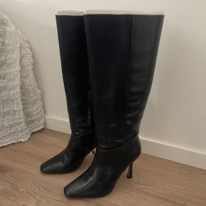 Svarta höga stövlar med klack - Knähöga stövlar från NA KD. Använda endast en gång så i fint skick. Storlek 37.  Nypris 899kr. 