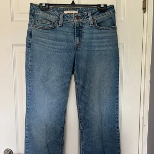 Levi's Superlow Bootcut jeans blå - Snygga blå Levi's Superlow Bootcut jeans i klassisk denim med låg midja. Modellen har bootcut-ben. Perfekta. Kostar mellan 700-800kr nya. Använda under 5 gånger då jag har ett par liknande jeans. Skriv privat för bättre bilder då jag inte fick med hela jeansen på bilderna.