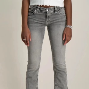 Grå bootcut jeans med kontrastsömmar - Snygga grå jeans med bootcut passform och dekorativa vita kontrastsömmar på bakfickorna. Skickar gärna fler bilder!💕💕