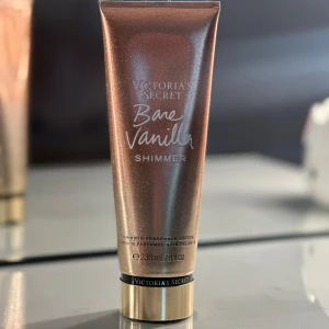 Victoria's Secret Bare Vanilla Shimmer - Bare Vanilla Shimmer från Victoria's Secret är en skimrande bodylotion med doft av vispad vanilj och mjuk kashmir. Tuben är bronsfärgad med guldigt lock och innehåller 236 ml. Ger huden ett glittrande skimmer och en söt, varm doft.