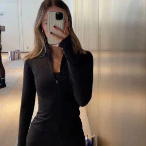  Lululemon define - HELT NY.svart träningsjacka från Lululemon med hel dragkedja framtill och höga fickor med dragkedja. Jackan har lång ärm, ståkrage och är gjord i ett stretchigt syntetmaterial som andas. Perfekt för gymmet eller powerwalks.