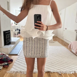  paljettkjol - Supersöt kjol! Kjolen är kort och täckt av glittriga paljetter i silver och grått. Perfekt för dig som vill sticka ut med en festlig look!