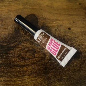 NYX The Brow Glue Medium Brown - NYX The Brow Glue i färgen Medium Brown är en färgad gel för ögonbryn som håller stråna på plats hela dagen. Testad en gång då färgen inte passade men älskade formulan 