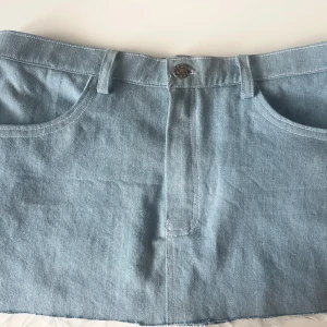 Lågmidjad jeanskjol - Snygg lågmidjad jeanskjol från en marknad i Spanien! Har ingen lapp så vet inte var den är ifrån samt är i storlek 36! 
