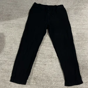 Svarta linne byxor från H&M - Svarta linne byxor från H&M. Perfekta för en avslappnad stil och bekväma dagar. Byxorna har en enkel och stilren design utan synliga detaljer eller mönster.