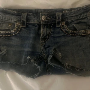 Jeansshorts med paljett-detaljer från Miss Me - Ljuset är ganska dåligt i rummet och den är inte grön aktig som på bilden utan blå. Den är i storlek 26 skriv till mig innan du köper annars finns det chans att jag avbryter köpet!