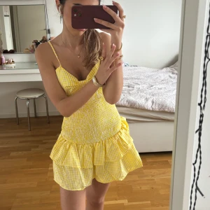 Gul och vit rutig volangklänning - Lägger ut igen pga oseriös köpare!! Jättesnygg och trendig klänning med justerbara band och knytning i ryggen (hade svart bh under på bilderna men funkar bäst utan eller med en vit) klänningen är stretchig och formar kroppen så snyggt😍😍