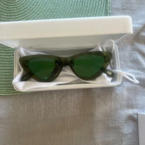 CHIMI gröna cat eye  - Snygga gröna solglasögon i cat eye-modell med transparent båge och matchande gröna glas. 