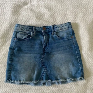 Blå jeanskjol från H&M - Säljer en klassisk blå jeanskjol från H&M i storlek 140. Justerbar midja! 