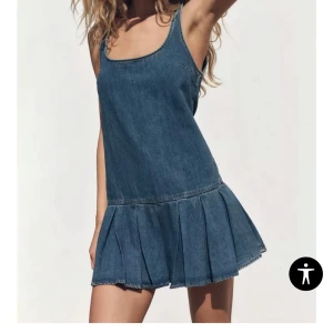 Jeansklänning - Säljer en snygg jeansklänning med rundad urringning och volang nedtill. Klänningen har en kort passform och är perfekt för sommaren.