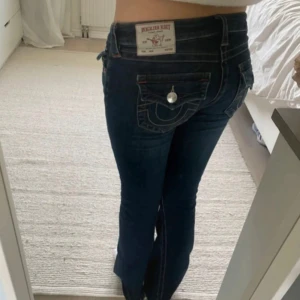 Mörkblå bootcut jeans från True Religion - Säljer ett par mörkblå jeans från True Religion med bootcut/flare passform. Jeansen är i modellen JOEY, w27, låg midjade. Inga defekter &köpta för 1200kr i december💘