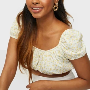 Blommig croppad topp med puffärm - Supersöt croppad blus med små gula blommor på vit botten. Helt oanvänd och så gullig nu till sommaren💕🫶🏼Kan posta paket omgående🥰