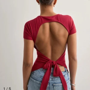 Snygg topp från Nelly  - Jätte fin röd topp med öppen rygg ifrån Nelly använd 1-2 gånger.