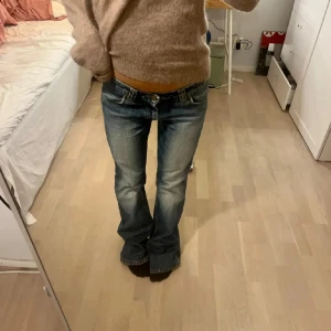 Blå bootcut jeans med låg midja - Säljer de perfekta lågmidjade Bootcut jeansen från lee. Jeansen har ett stort hål på vänster knä som ger en extra snygg touch och är väldigt inne just nu( större än på bilden).  Jag ÄLSKAR verkligen dessa men de är lite långa på mig. Midjemått 35 Innerbenslängd 82 cm. Tryck gärna på köp nu😍😍