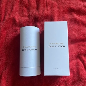 Imagination Eau de Parfum från Louis Vuitton - Imagination från Louis Vuitton är en exklusiv Eau de Parfum i en elegant genomskinlig flaska med svart kork. Förpackningen är vit med guld- och svart text, och flaskan rymmer 100 ml. Lyxig och stilren design med klassisk Louis Vuitton-logga på locket.