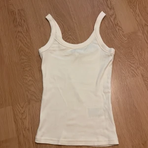 Ljusgul ribbad linnetopp från Gina Tricot - Säljer en ljusgul ribbad linnetopp från Gina Tricot i modellen elevated basics. Toppen har en tight passform och är ärmlös med breda axelband. Perfekt att styla till olika outfits! Säljer för den är för stor aldrig använd!