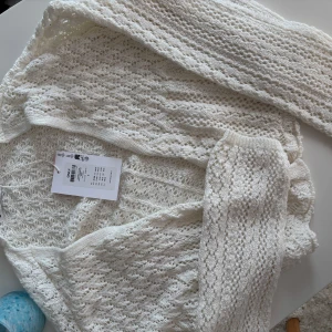 Vit stickad kofta från ONLY - Säljer en vit stickad kofta från ONLY i storlek S. Koftan har ett vackert spetsliknande mönster🤍🤍aldrig använd!! 