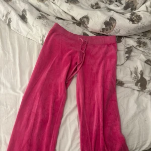 Rosa velourbyxor från Juicy Couture - Säljer ett par klassiska rosa velourbyxor från Juicy Couture med dragsko i midjan. Byxorna har en loose passform och bred resår i midjan. Perfekta för en avslappnad och trendig look. Har knappt använt dem, inget som är sönder eller så!