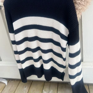 Svartvit randig stickad tröja från Gina Tricot - Säljer en stickad tröja från Gina Tricot i svart och vitt med breda horisontella ränder. Tröjan har lång ärm och ribbade muddar vid ärmslut och nederkant.    SKRIV INNAN KÖP!      Endast använd ett par fåtal gånger❤️