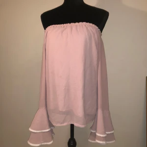 Smutsrosa offshoulder - Söt rosa offshoulder blus volangdetaljer. Ärmlängd ca 60cm. Längd ca 50cm. Står ingen storlek i men uppskattar att det är en M.