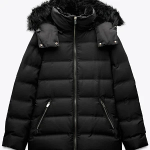 Svart dunjacka med fuskpäls - Snygg svart dunjacka med avtagbar huva och fuskpälsdetaljer. Jackan har dragkedja framtill och praktiska fickor med dragkedjor. Perfekt för kalla dagar, säljer denna fina vara eftersom den blivit för liten för mig, den e håller en varm och är väldigt bekväm, passa på och köp😉💗