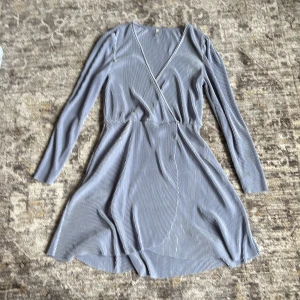 Ljusgrå omlottklänning med smala ränder - En jättefin långärmad ljusblå klänning i tunt tyg 