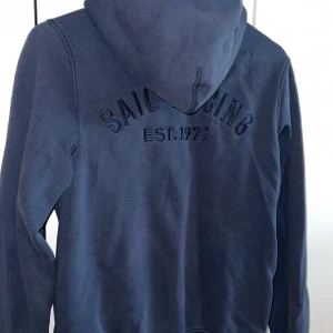 Mörkblå hoodie från Sail Racing - Sail racing kofta, marinblå. Stl L dam, bör passa M också. Hör av er vid frågor eller för fler bilder.