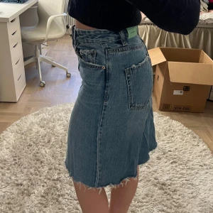 Blå jeanskjol med rå kant - Säljer en blå jeanskjol från stradivarius. Knä längd/midi kjol