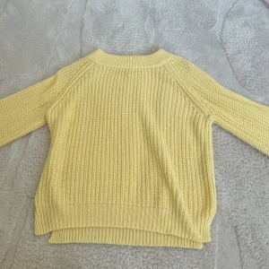 Gul stickad tröja - Säljer en härlig gul stickad tröja med rund hals och långa ärmar. Perfekt för att lysa upp garderoben med en färgklick. Tröjan har en ribbad struktur som ger en fin textur och stil. Jag är 163cm men tröjan är 134/146 så den är lite större 