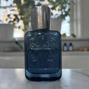 Sedley Parfums de Marly - Elegant flaska i mörkblått glas med silverfärgat lock. Parfymen Sedley från Parfums de Marly erbjuder en fräsch och modern doft. Kvitto finns, men inte låda! Flaskan har en stilren design med ingraverade detaljer och rymmer 75 ml. Ca 60% kvar av flaskan, alltså runt ~ 45-50 ml. Hör av er vid minsta fråga eller fundering! 