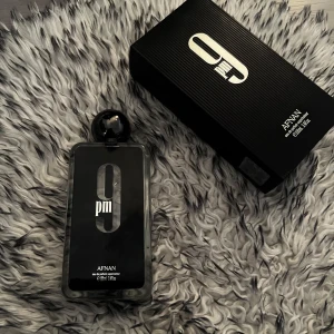 9 PM Eau de Parfum från Afnan - Säljer en elegant 9 PM Eau de Parfum från Afnan. Flaskan är svart med en stilren design och har en kapacitet på 100 ml. Finns 80ml kvar i den!! Förpackningen är också svart med en textur som ger ett lyxigt intryck. Perfekt för kvällsanvändning.