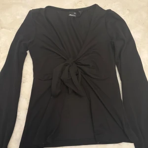 Svart långärmad topp med knyt framtill - Fin tröja från Gina tricot, tröjan är använd men finns inga defekter och är i ett fint skick.💞
