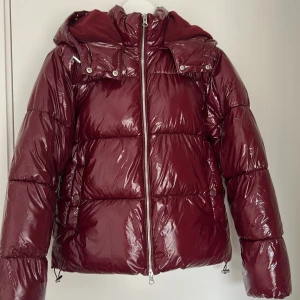 Vinröd pufferjacka från Nelly - Säljer den slutsålda pufferjacka från Nelly för bra pris. Prislapp sitter inte kvar, men den är aldrig använd och har inga skador. 