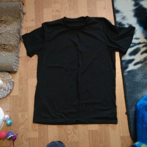 Svart t-shirt - En klassisk svart t-shirt med rund hals och korta ärmar. Perfekt basplagg som passar till det mesta. Enkel och stilren design utan tryck eller mönster.