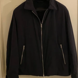Mörkblå jacka med dragkedja - Snygg mörkblå jacka i nyskick från Massimo Dutti med dragkedja framtill och två fickor med dragkedjor. Perfekt för en stilren look. (Köpt för 1400kr)