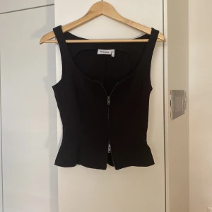 Svart korsettopp från Weekday - Snygg svart korsettopp från Weekday med dragkedja framtill. Dragkedjan går åt båda hållen så man kan välja hur man vill bära tröjan, figurnära passform