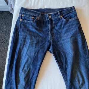 Levis 511 jeans  - Snygga Levis 511 jeans i en klassisk blå färg. Dessa jeans har en normal passform och är tillverkade i slitstarkt denim. Perfekta för en stilren look med fem fickor och knappgylf. Lite mindre i storleken och är tapered.