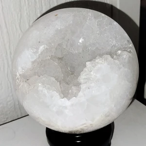 Vit kristallkula - Vacker vit kristallkula med en naturlig, rå yta som ger en unik och mystisk känsla. Perfekt som dekorativt inslag i hemmet eller för meditation och energiarbete.