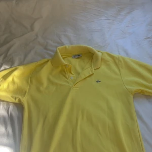 Lacoste piké - Säljer en splitterny lacoste piké, inte använt för den var för stor. men riktigt fräsch inför sommaren