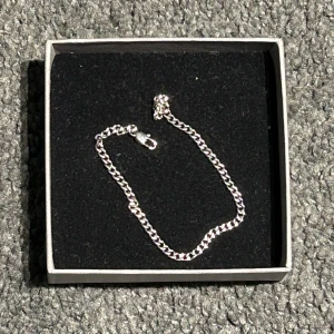Silverfärgat armband - Elegant silverfärgat armband med en klassisk kedjedesign. Perfekt för att lägga till en touch av stil till vilken outfit som helst. Levereras i en stilren ask. Helt nytt och ny pris 399kr