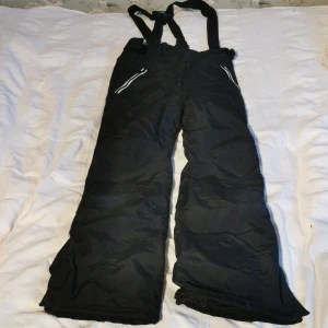 Svarta täckbyxor från Everest - Säljer ett par täckbyxor från Everest för barn runt 5-6 år! De är vattentäta och har ett skönt foder i byxorna så att man blir varm. Byxorna är använda men det är inget man ser! 😄 Byxorna har också hängslen och reflexer på sig! Säljer de för ett bra pris! 👍🏻💛