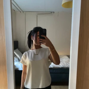 Vit blus med öppen rygg - Säljer en stilren vit blus med korta ärmar och en elegant öppen rygg med knytning. Perfekt för en chic och modern look. Passar bra till både jeans och kjol.från Zara köpt för 300 använt bara några gånger. 