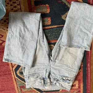Ljusblå jeansbyxor low waist, Gina tricot - Säljer ett par ljusblå jeansbyxor med en klassisk design. Byxorna har en rak passform och är tillverkade i denim. Perfekta för en avslappnad stil.