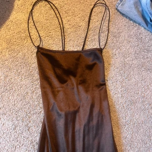Brun klänning från H&M  - Säljer denna snygga stilrena bruna klänningen från H&M Divided med tunna band som tyvärr ej kommer till användning. Strl XS och väldigt fint skick! Skulle säga att den är mer åt det korta hållet  💕